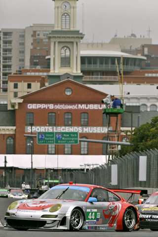 Flying Lizard Porsche 911 Through Turn 3 w/Sports Museum in Background