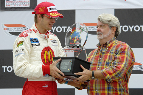 George Lucas Hands Winning Trophy to Sebastien Bourdais