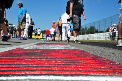 Fans milling around on pre-grid walk near curbing