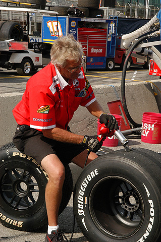 Crew Member Scrubbing Tire of Buildup