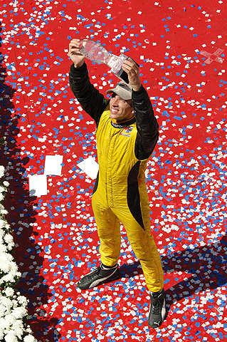 Justin Wilson Holding Trophy Aloft on Podium