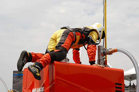 Crewman on Top of Fuel Cell Looking Down Nozzle