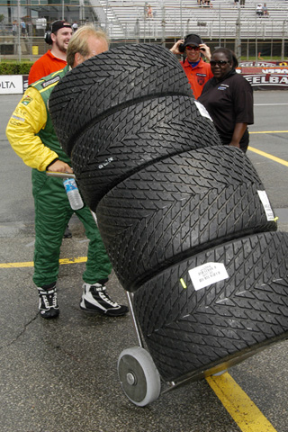 Crew Member Wheeling Stack of Rain Tires