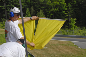 Corner Worker Holding Up Double Yellow Flags Image